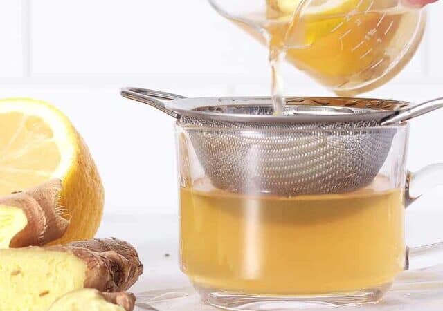 ginger tea being poured through a strainer