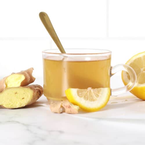 a cup of ginger tea with lemon slices and ginger slices