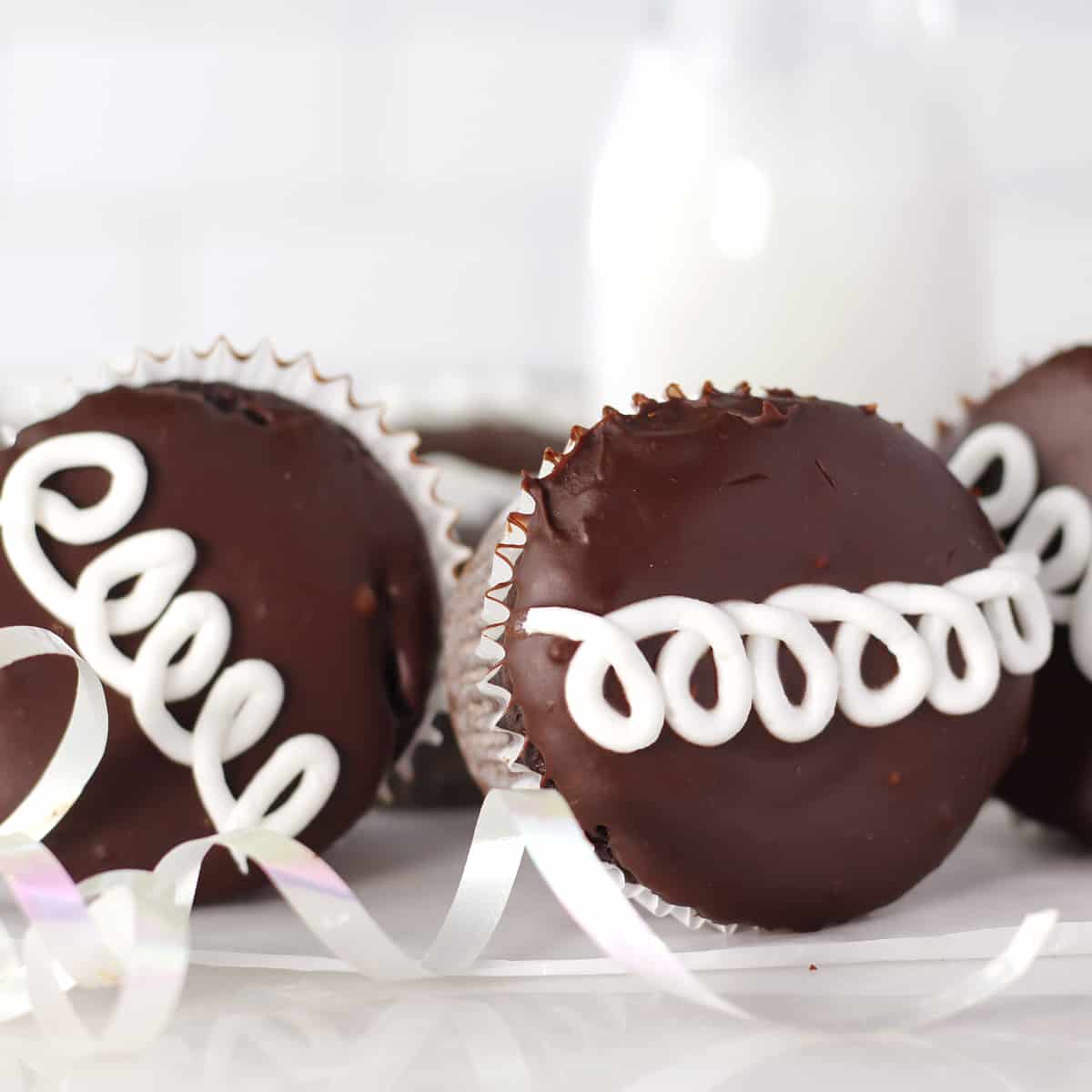 homemade hostess cupcakes tilted on a white table with a ribbon.