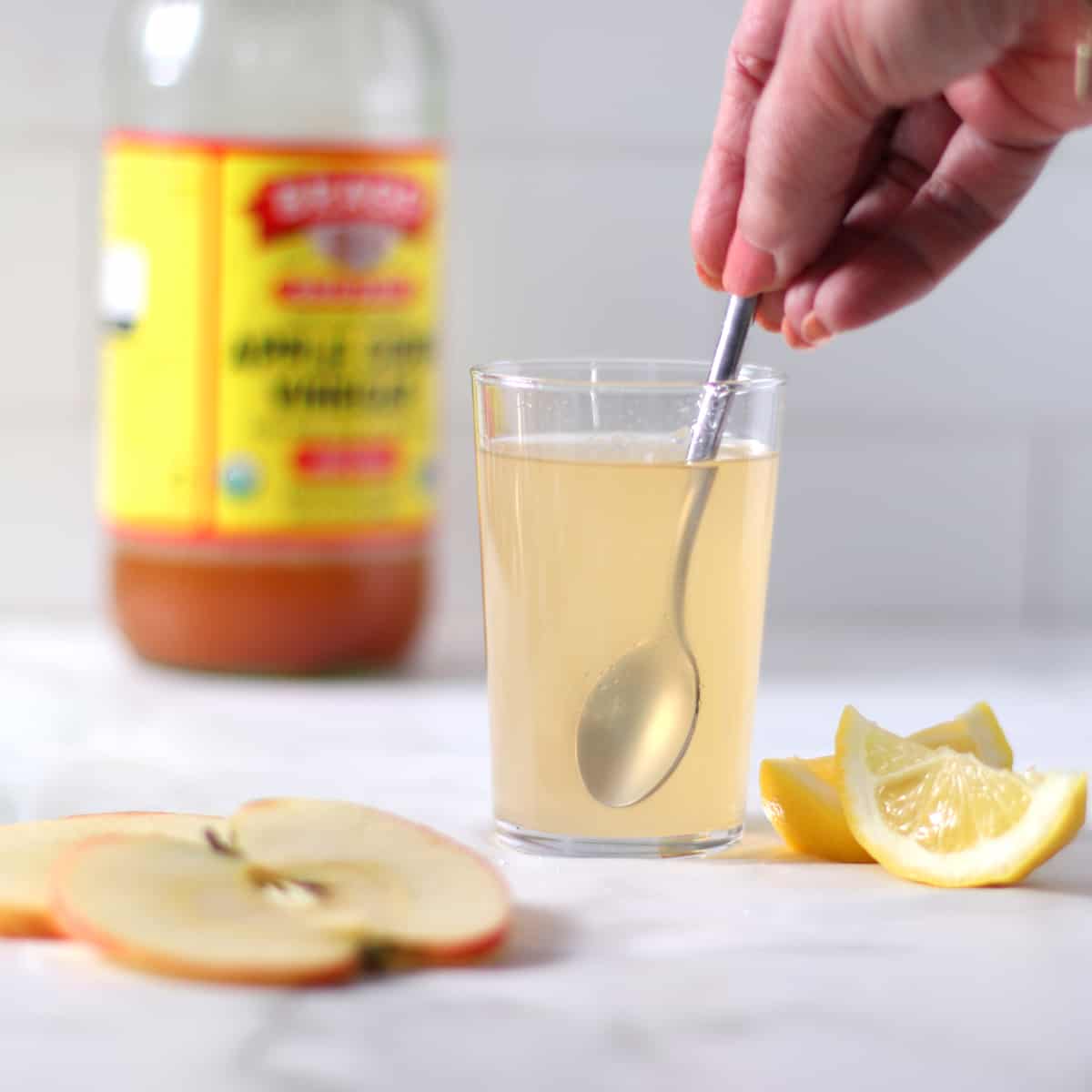 a glass of apple cider vinegar drink with spoon