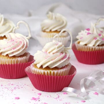a vegan vanilla cupcake on a white table with white frosting
