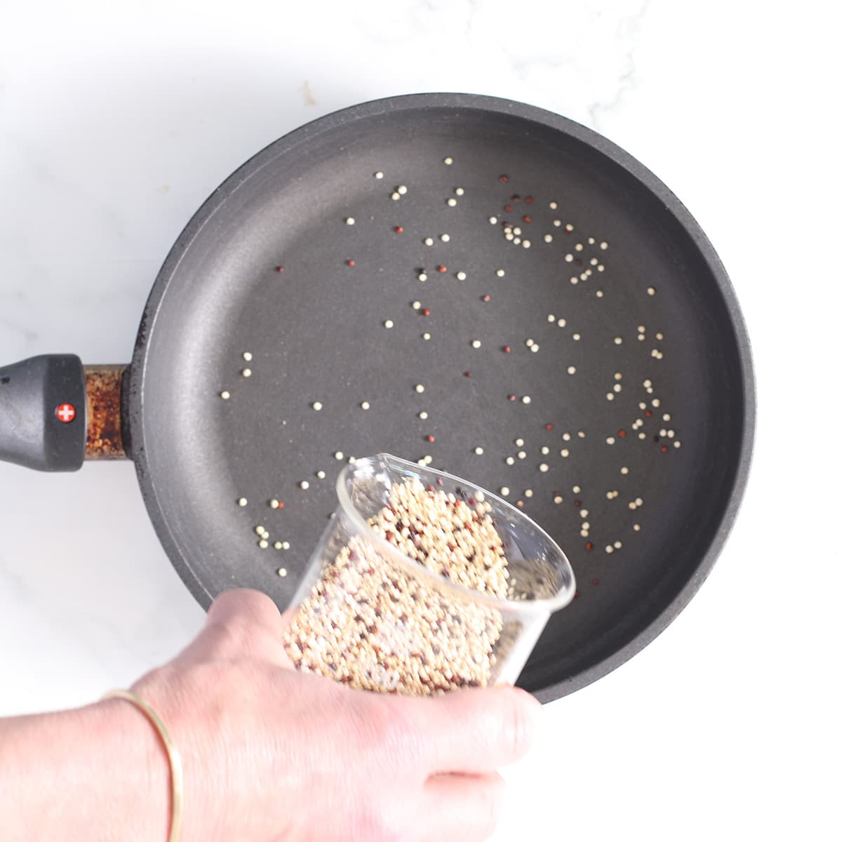 pouring quinoa into pan.