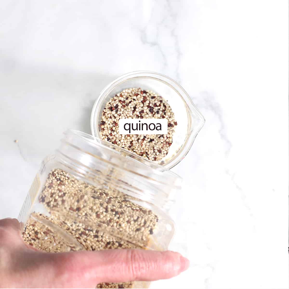 quinoa pouring from a container into a cup