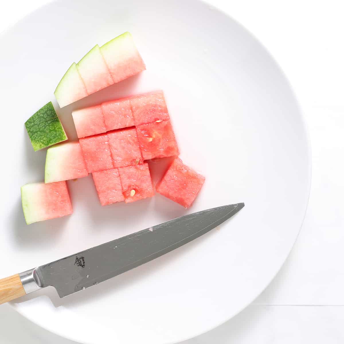 watermelon chunks being chopped
