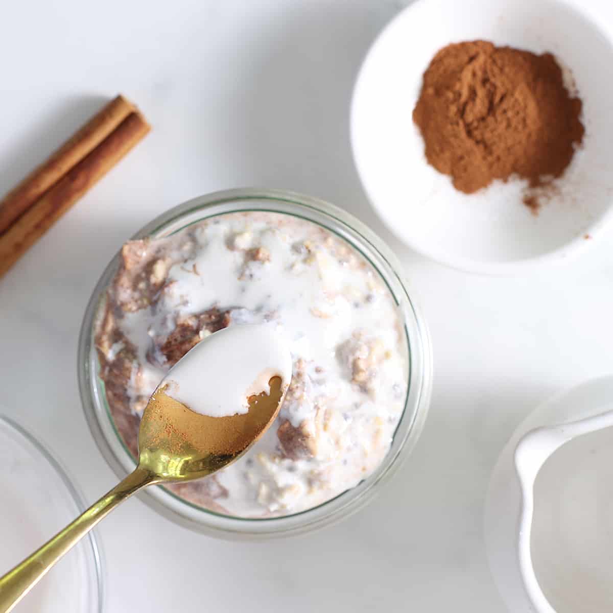 cinnamon overnight oats with glaze and a gold spoon.