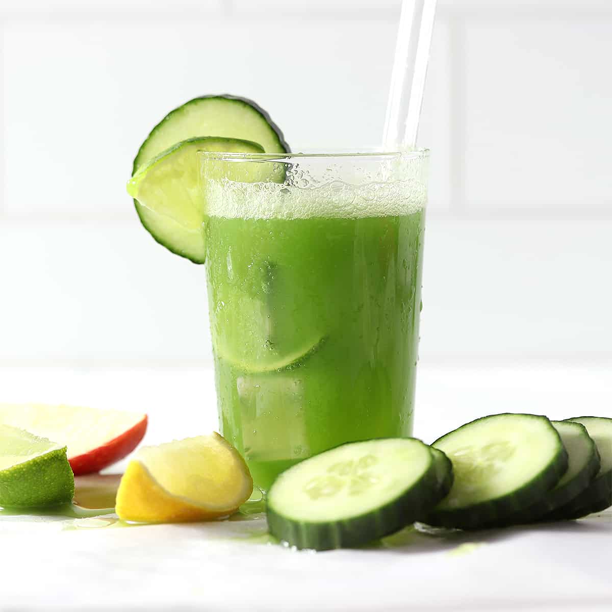cucumber juice with foam top and sliced cucumbers.
