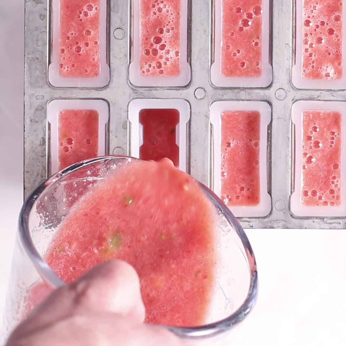 pouring watermelon popsicle mixture into mold