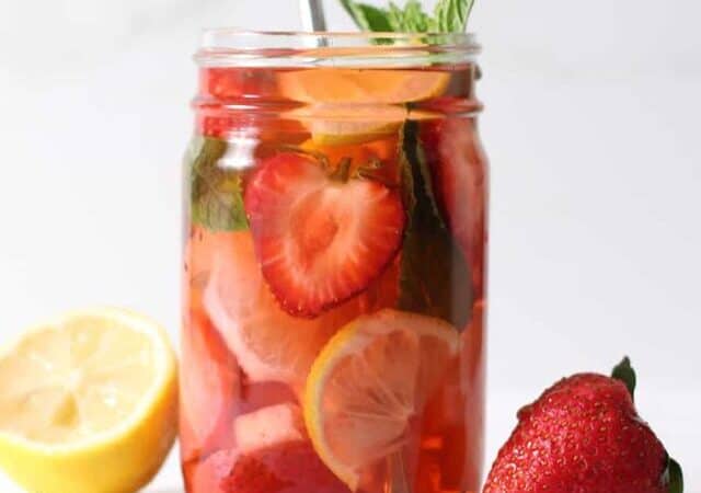 jar of strawberry water with lemon on one side, strawberry on the other.