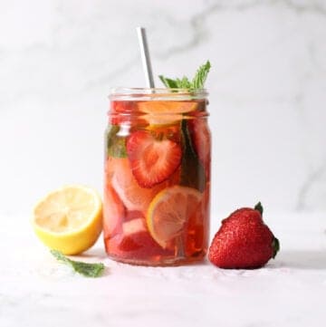 jar of strawberry water with lemon on one side, strawberry on the other.