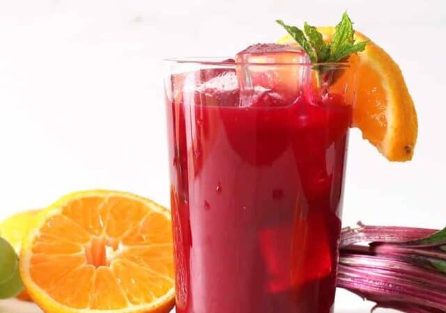 glass of beet juice with orange slices and mint.