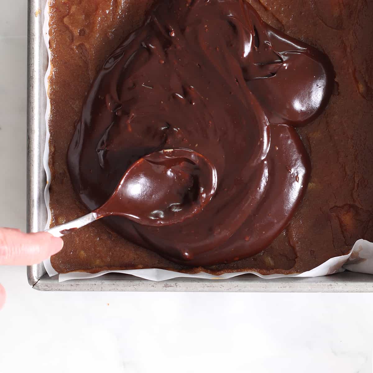 add melted chocolate to the top of chocolate coconut bars.