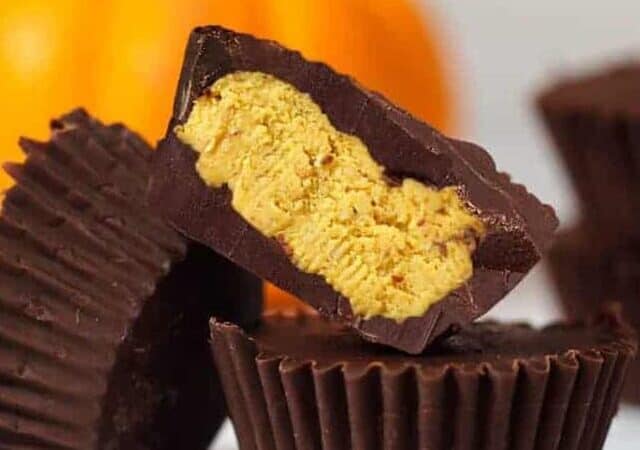 cups of pumpkin fudge coated in chocolate in a tower.