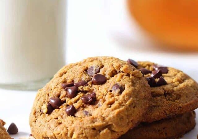 pumpkin oatmeal chocolate chip cookies stacked with a milk bottle.