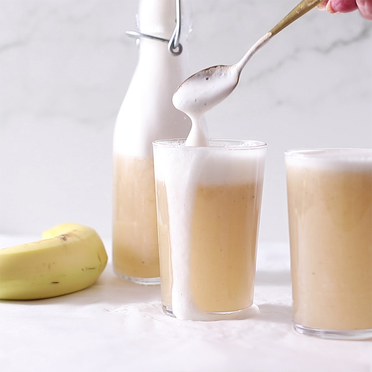 banana milk in a glass with foam top.
