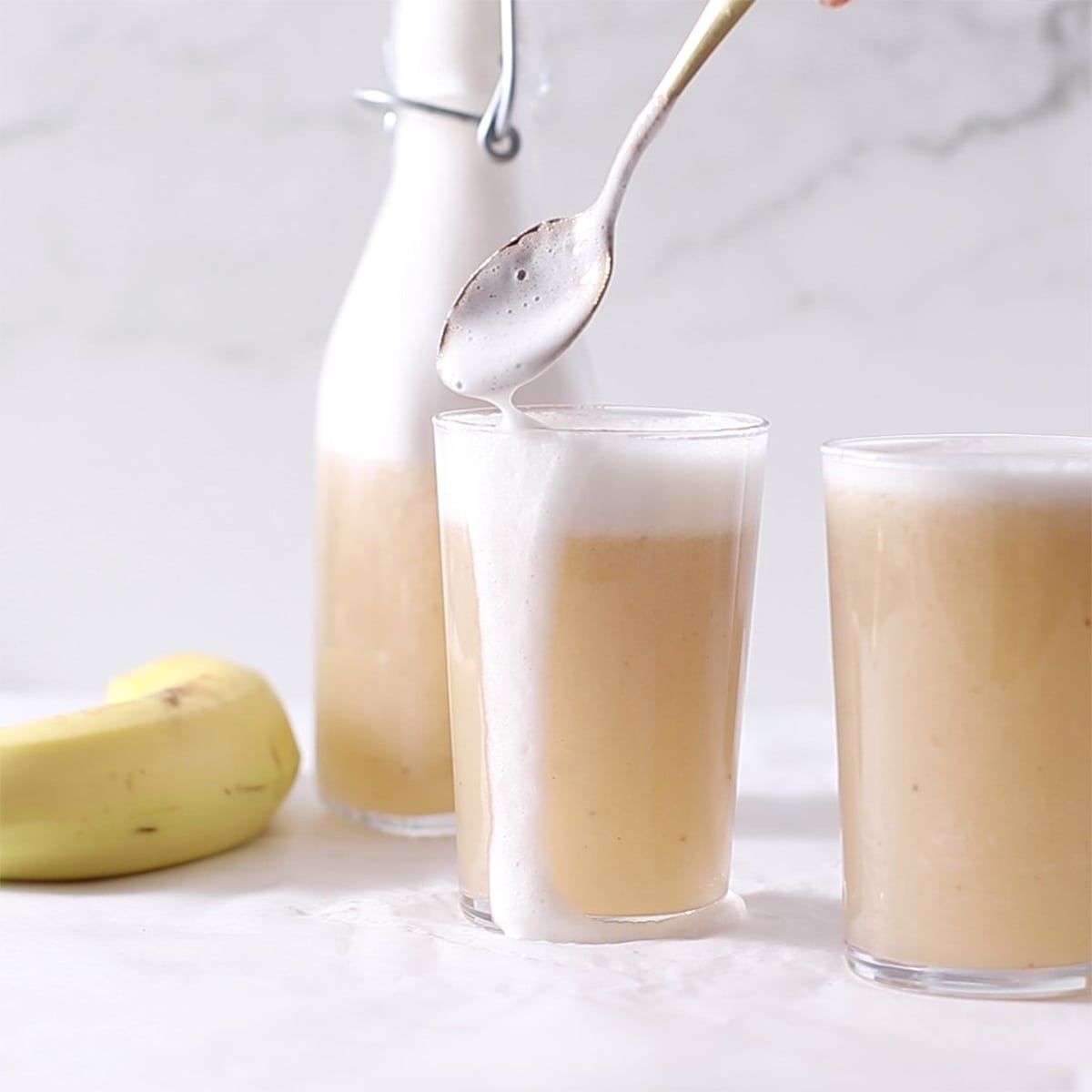 banana milk in a glass with foam top.