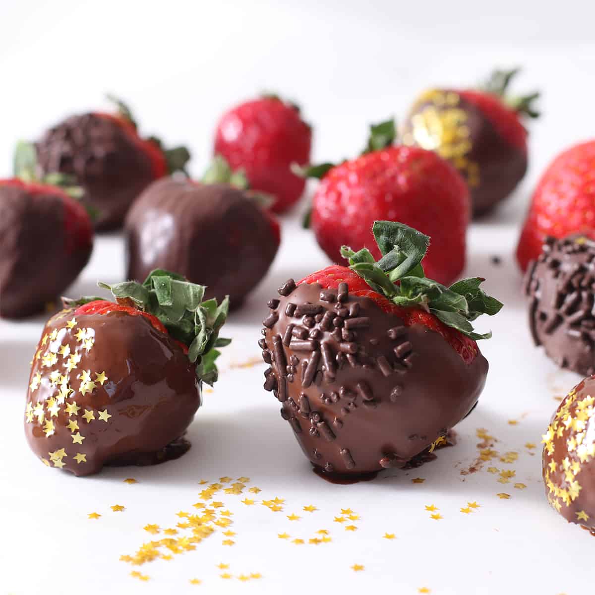 dipped chocolate covered strawberries on a table.