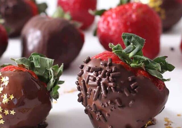 dipped chocolate covered strawberries on a table.