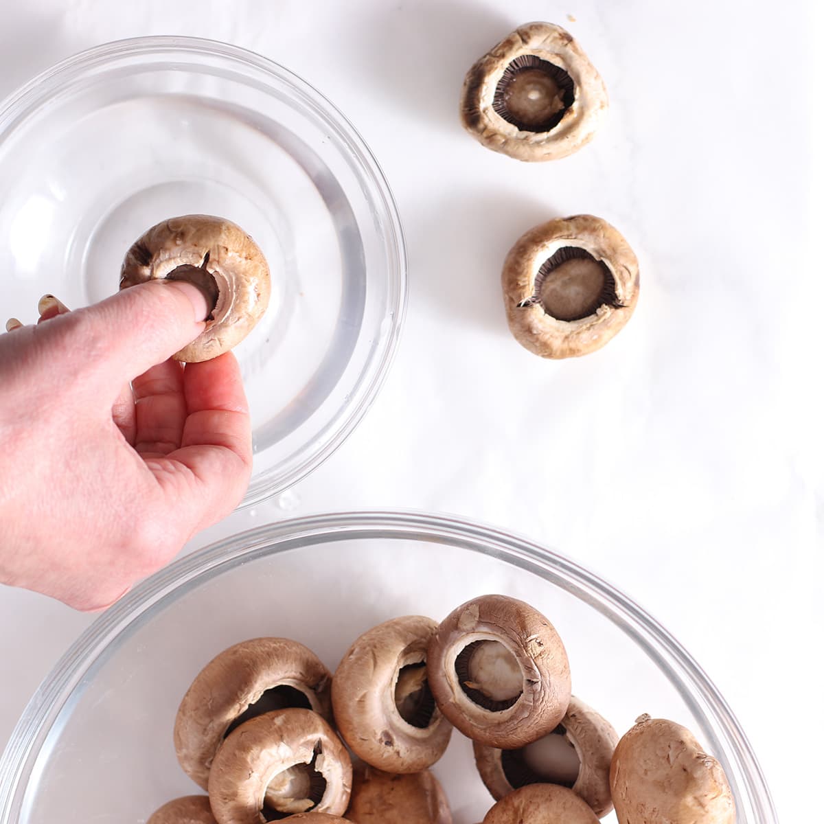 washing mushrooms in a bowl of water.