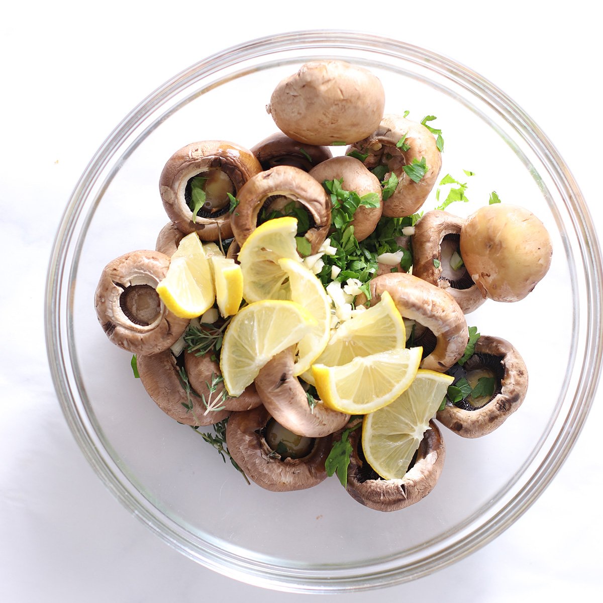 mushrooms in a bowl with other ingredients to be roasted.