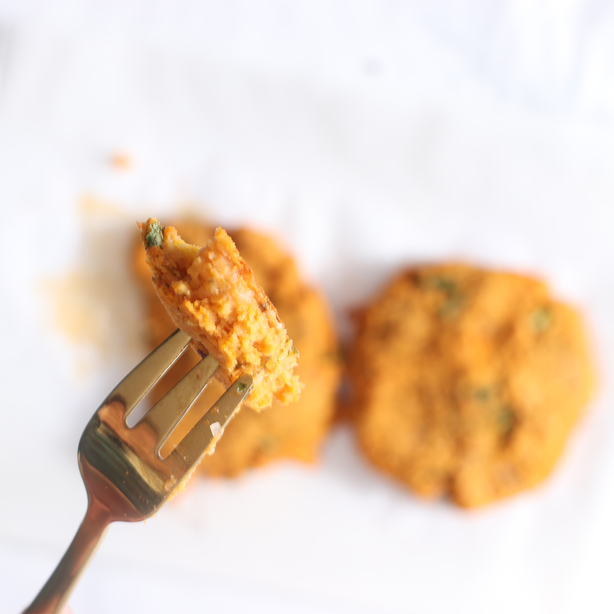 baked chickpea burgers with a bite on a fork.
