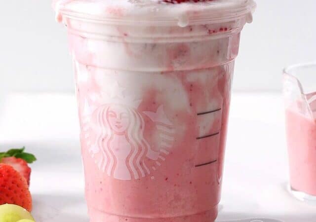 pink drink with cold foam and strawberries on top.