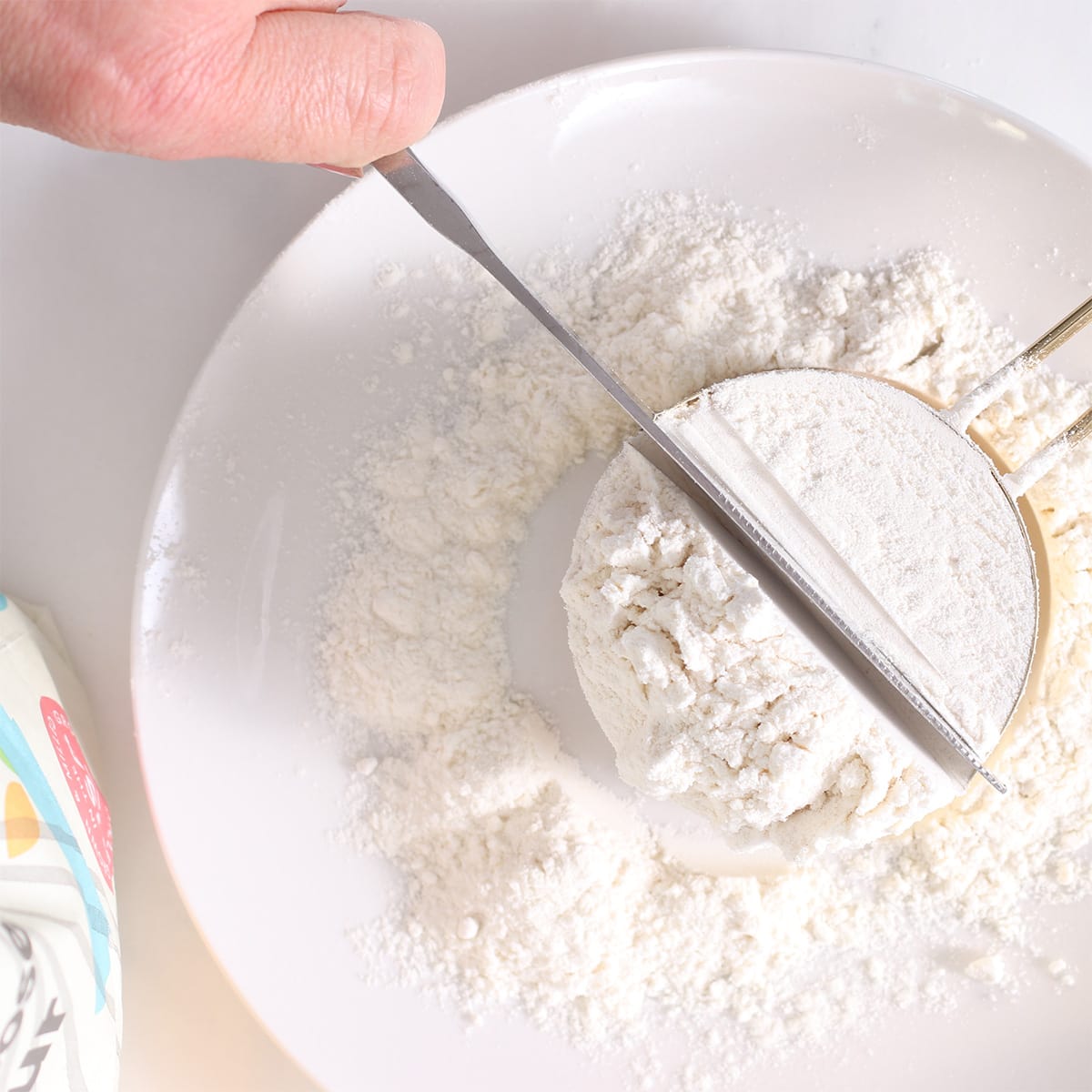 leveling a cup of flour with a knife.