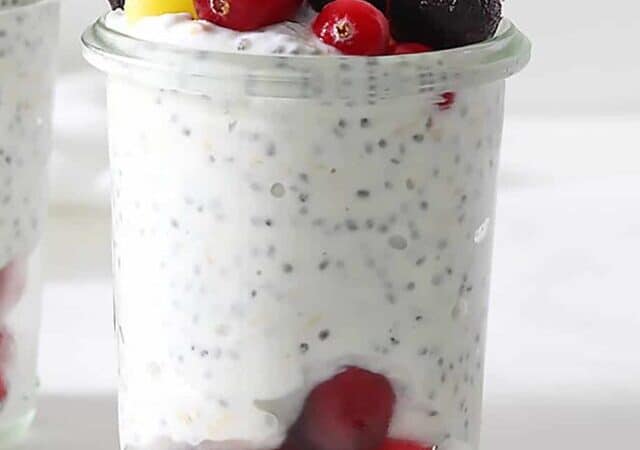 high protein overnight oats in two glasses with fruit.