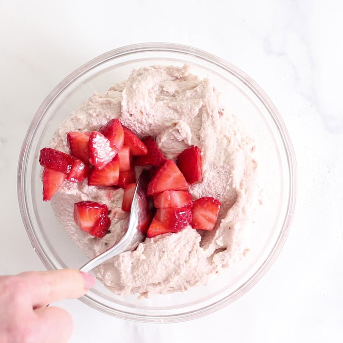 strawberry frozen yogurt cookie dough in a bowl with chopped strawberries.