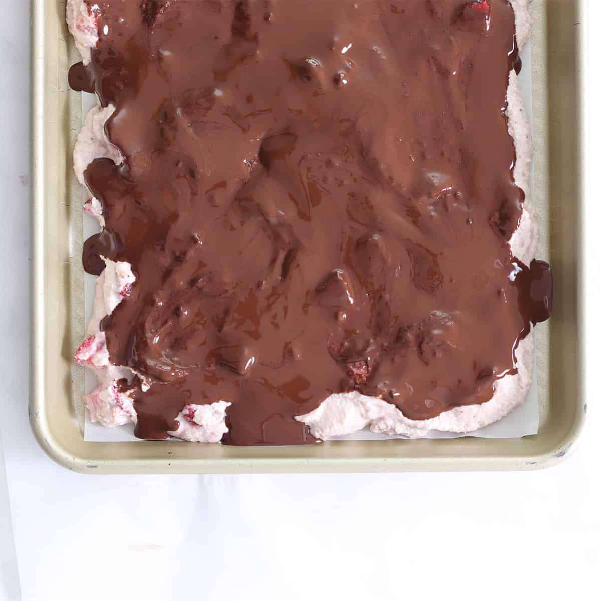 strawberry frozen yogurt cookie dough spread on pan with chocolate.