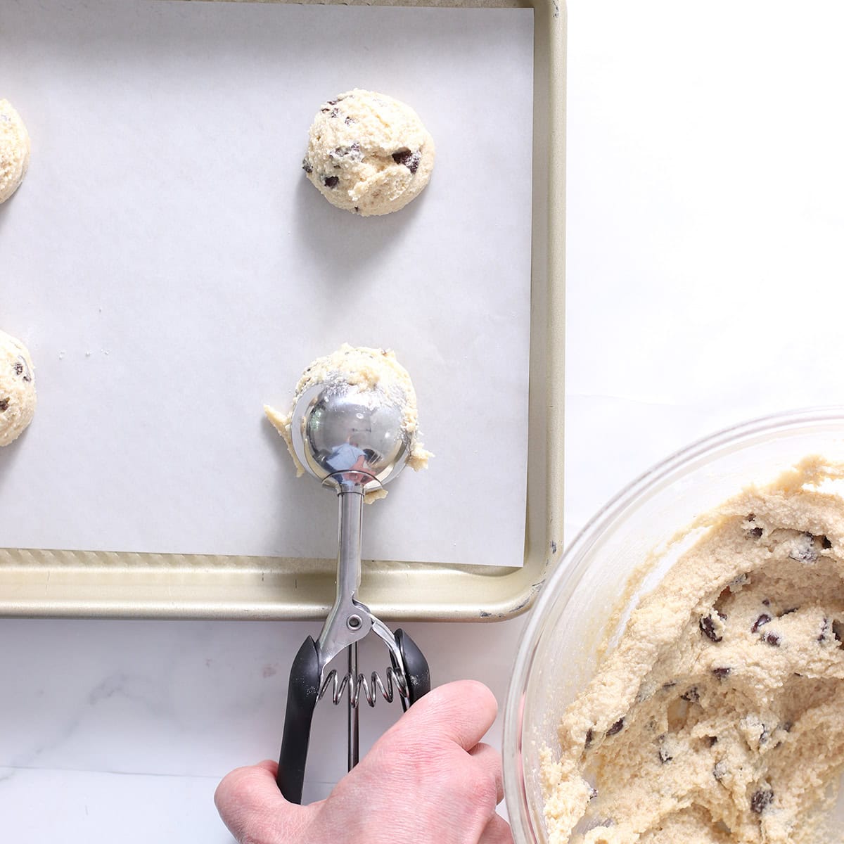 thin and crispy chocolate chip cookies made with almond flour batter scooped.
