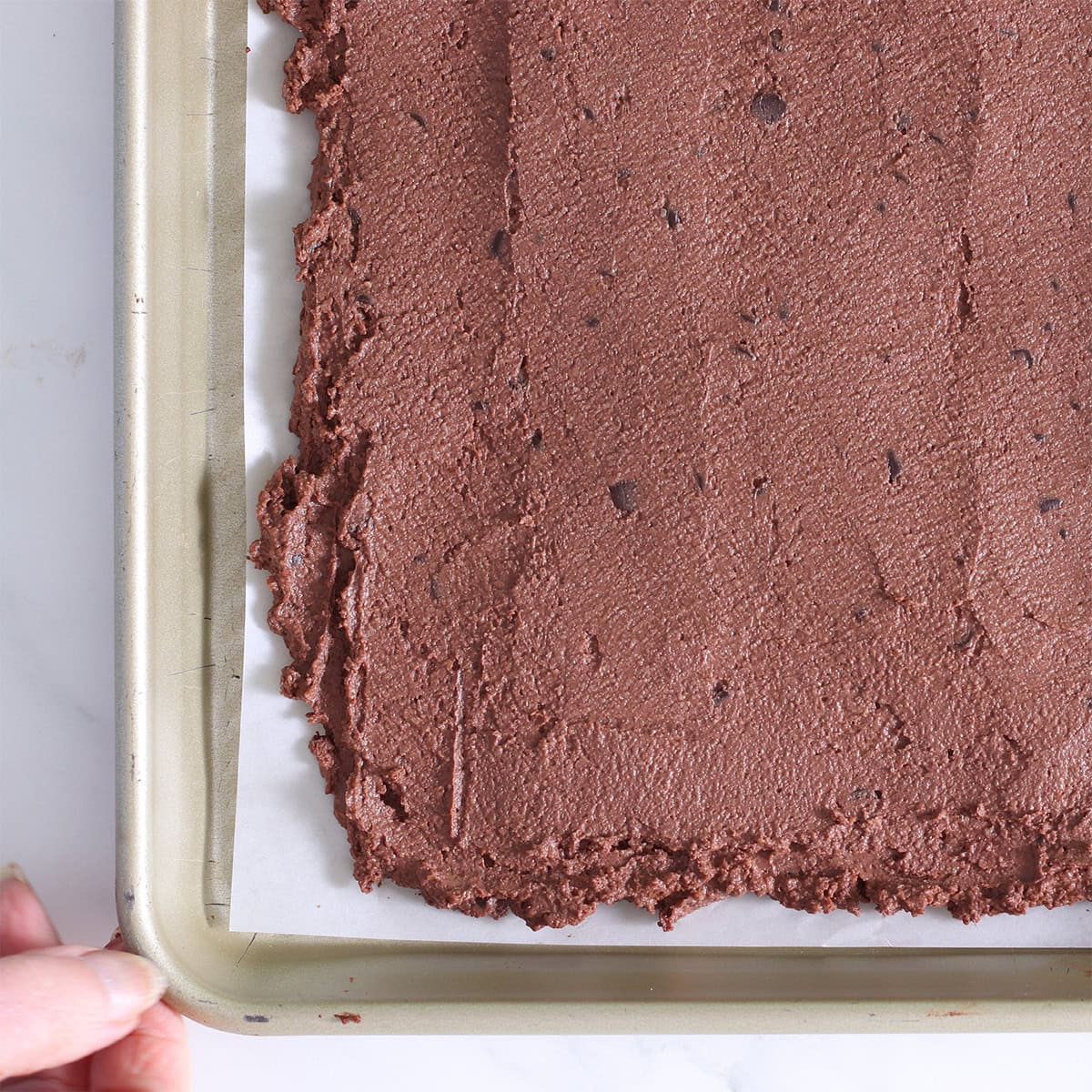 brownie bark batter spread on a pan.