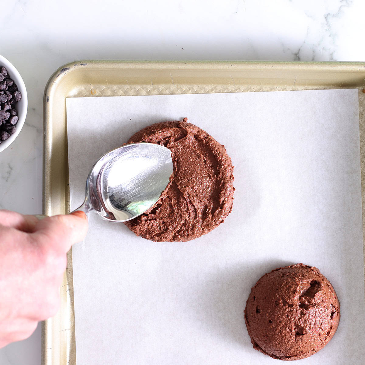 chocolate frozen yogurt pops scooped onto a pan.