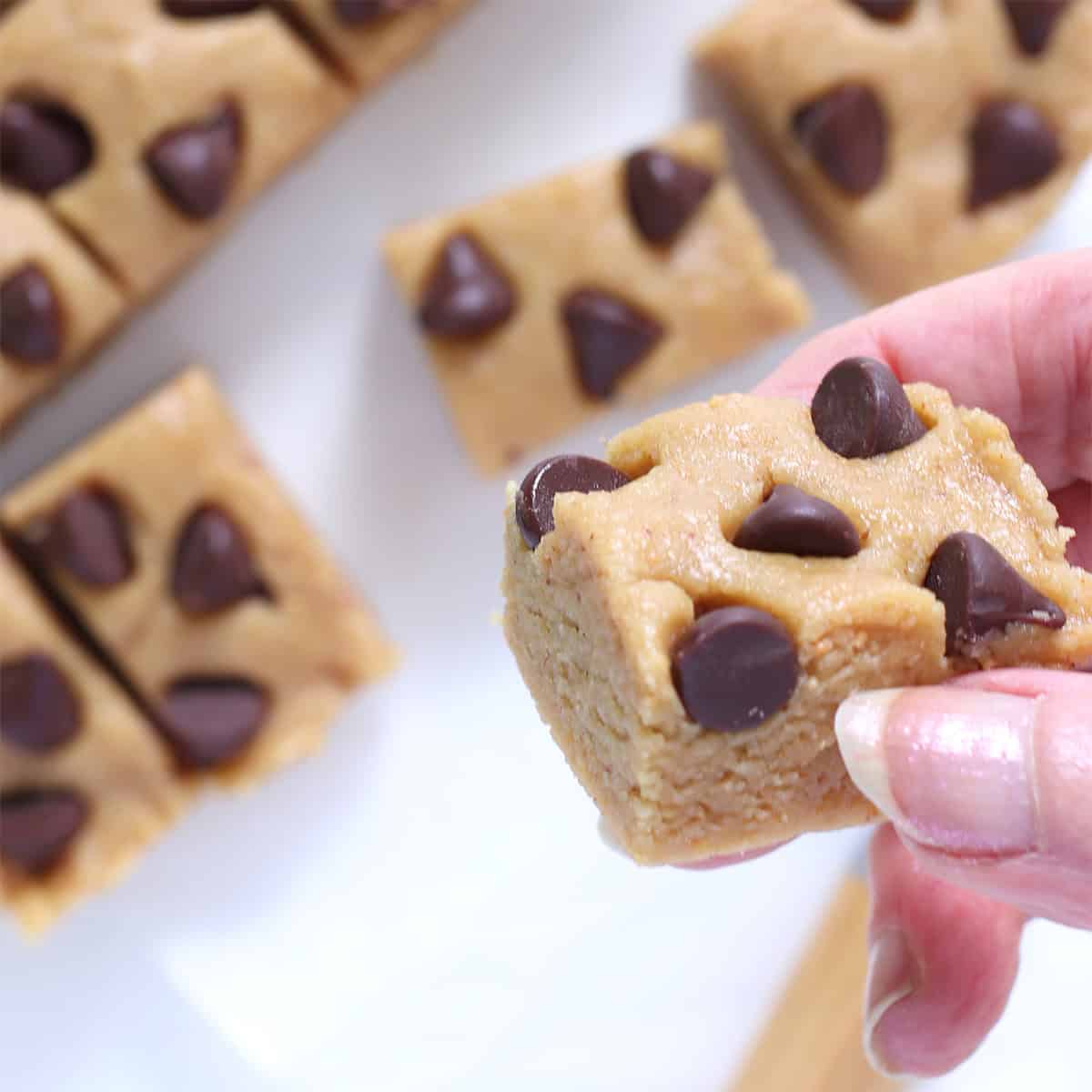 holding a square of peanut butter cookie dough.