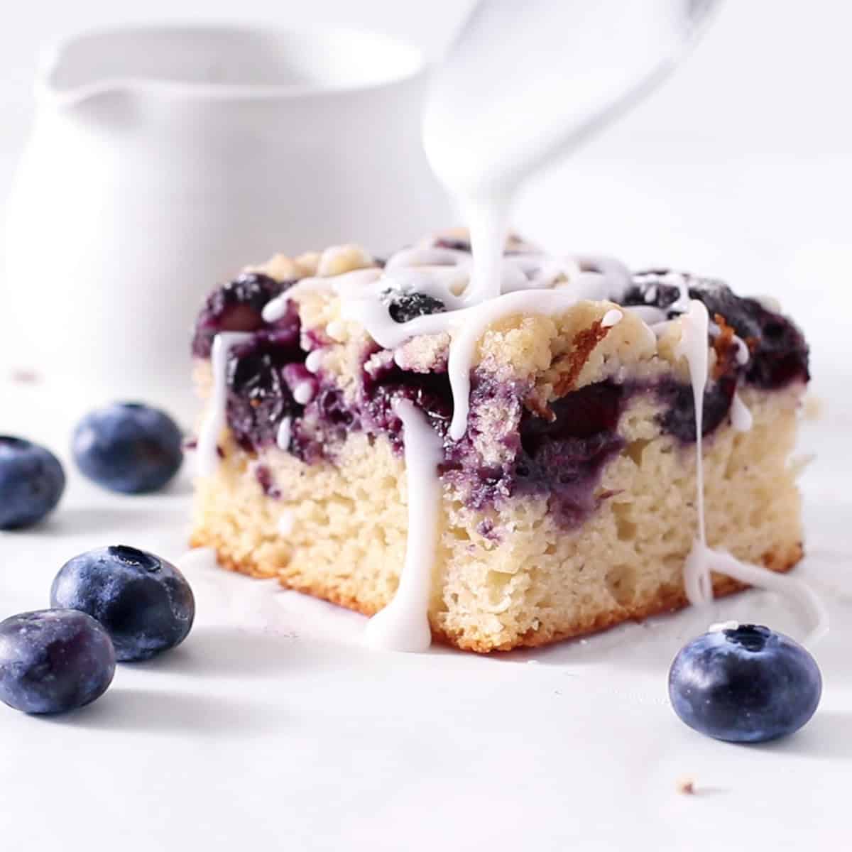 lemon blueberry crumb cake slice with glaze.