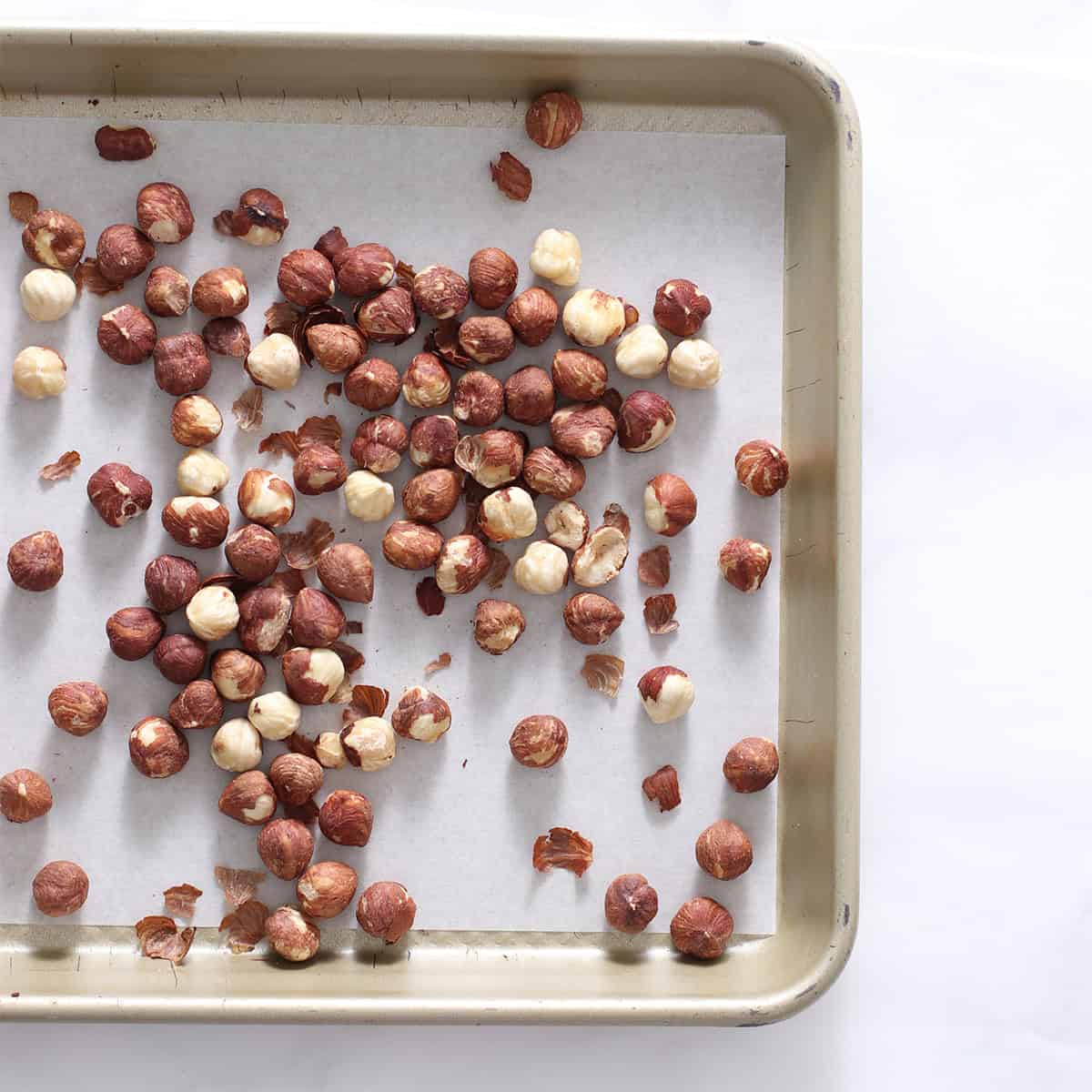 hazelnuts with skins on a pan.