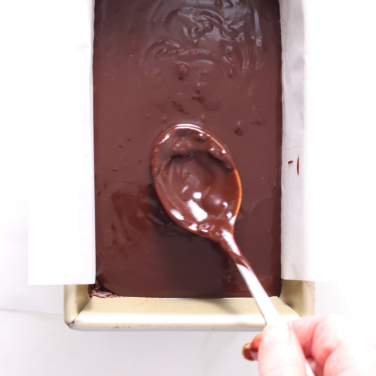 pouring ganache over chocolate hazelnut bars.