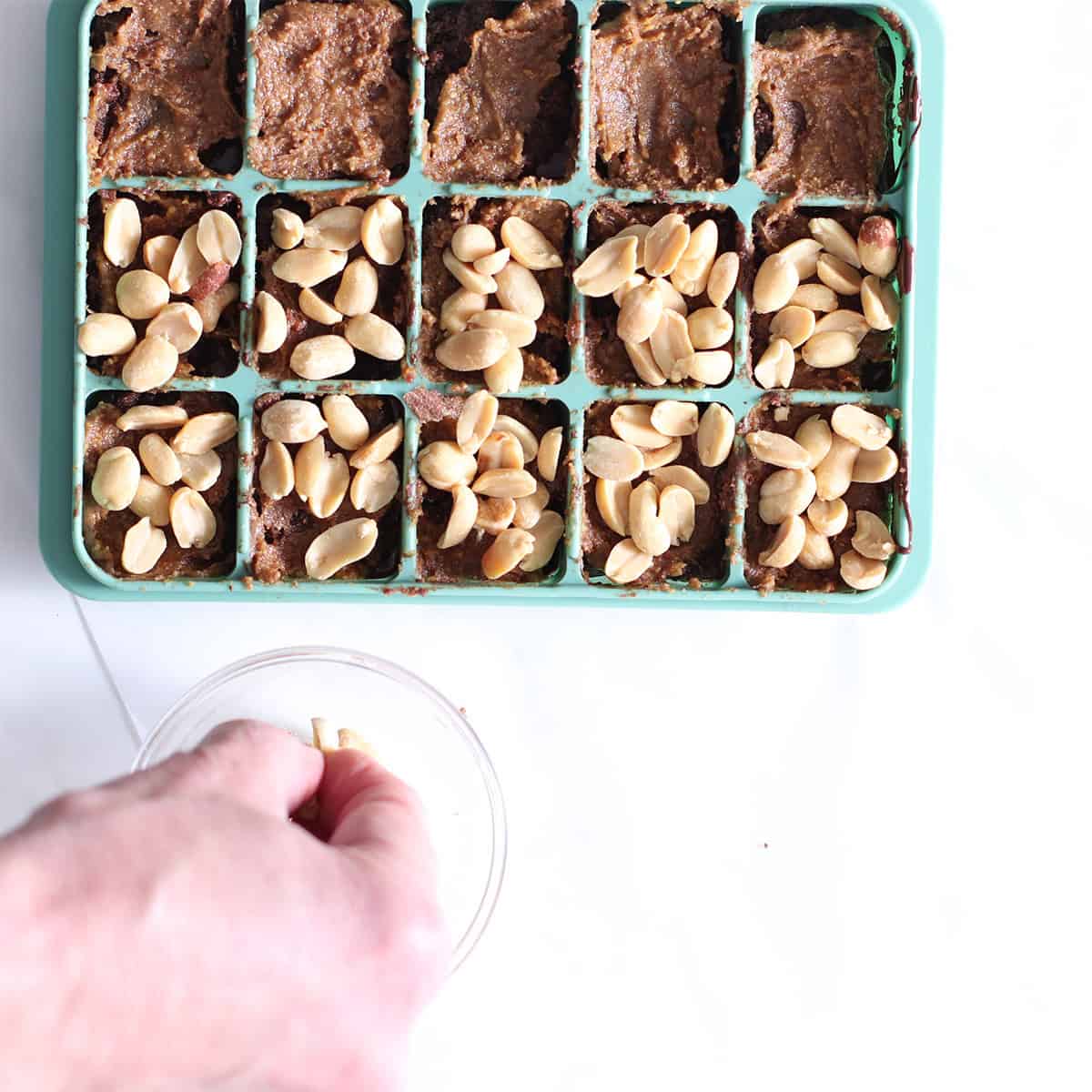 snickers brownie bites with nuts on top.