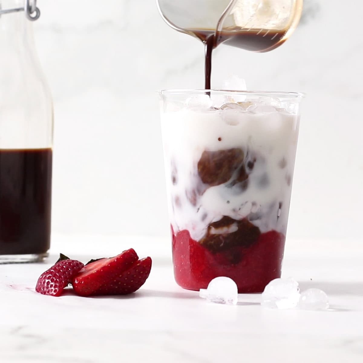 pour coffee syrup into strawberry latte.